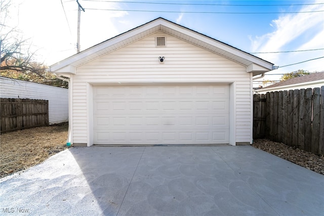 detached garage featuring fence