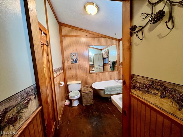 bathroom featuring toilet, wooden walls, hardwood / wood-style floors, and ornamental molding