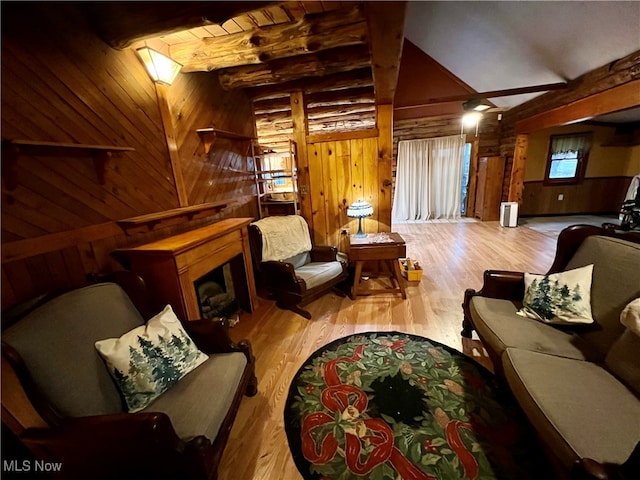 living room featuring wood walls, wood-type flooring, and vaulted ceiling with beams