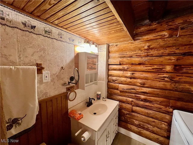 bathroom featuring wooden ceiling, rustic walls, and vanity