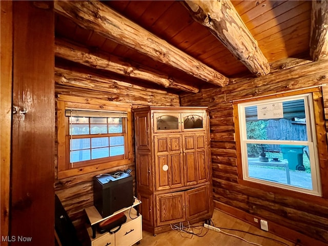 interior space with rustic walls, light hardwood / wood-style floors, beamed ceiling, and wood ceiling