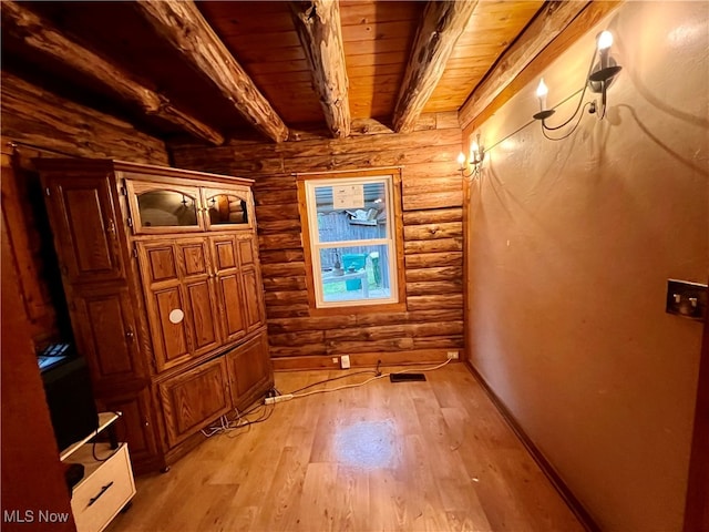 interior space featuring light wood-type flooring, log walls, beam ceiling, and wooden ceiling