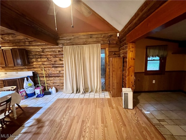 interior space featuring lofted ceiling with beams, ceiling fan, light hardwood / wood-style floors, and log walls