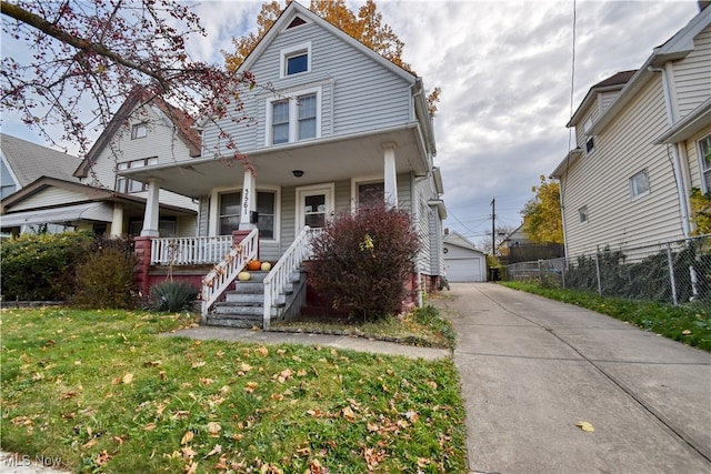 view of front of home with an outbuilding, a porch, a front lawn, and a garage