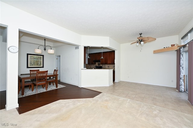 interior space with ceiling fan with notable chandelier and a textured ceiling