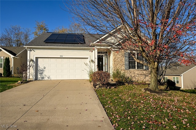 view of front facade with a garage, solar panels, and a front yard