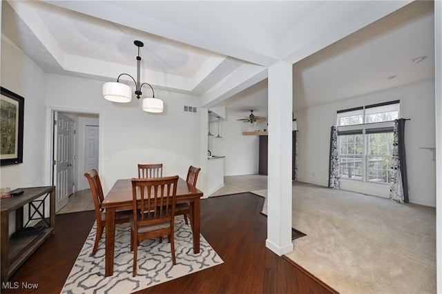 dining area with a tray ceiling, hardwood / wood-style floors, and ceiling fan