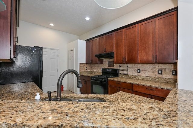 kitchen featuring black appliances, backsplash, a textured ceiling, light stone countertops, and sink