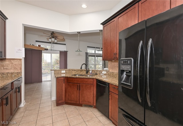 kitchen with kitchen peninsula, hanging light fixtures, black appliances, sink, and tasteful backsplash