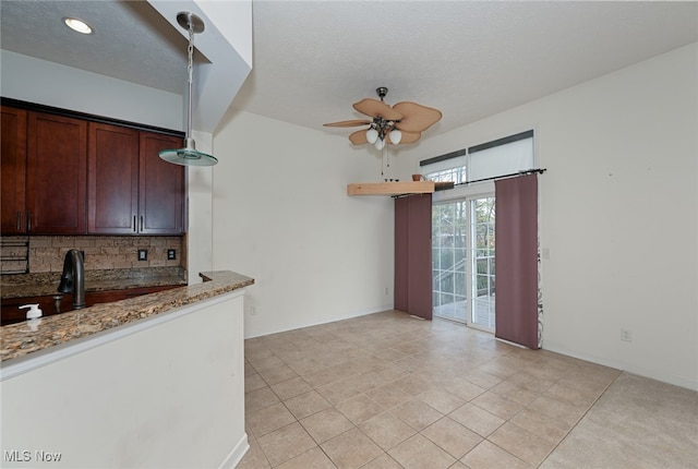 kitchen with sink, ceiling fan, light tile patterned flooring, backsplash, and light stone countertops