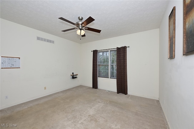 unfurnished room with a textured ceiling, light carpet, and ceiling fan