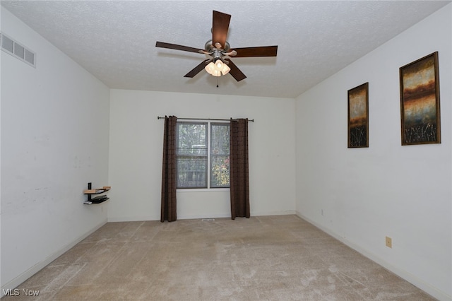 carpeted empty room with a textured ceiling and ceiling fan