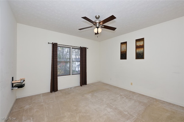 carpeted empty room featuring a textured ceiling and ceiling fan