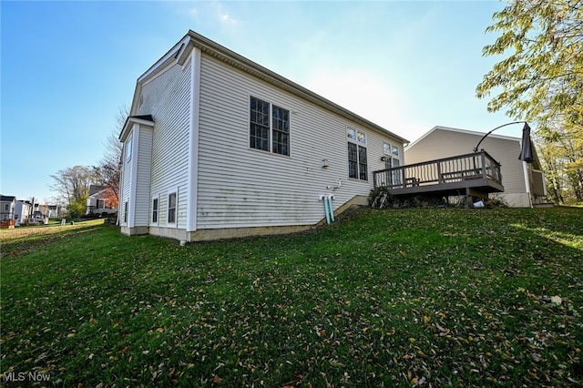 rear view of property with a wooden deck and a yard