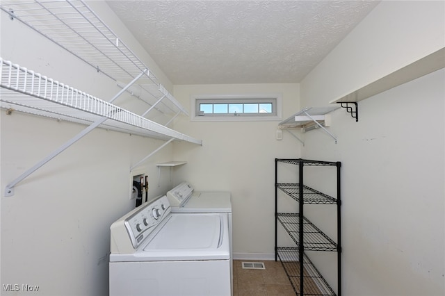 clothes washing area featuring washing machine and dryer and a textured ceiling