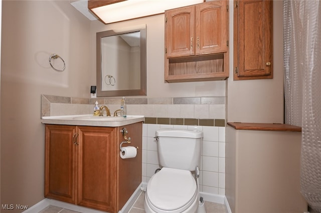 bathroom featuring tile walls, vanity, tile patterned floors, and toilet