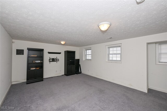 basement featuring a textured ceiling and carpet flooring