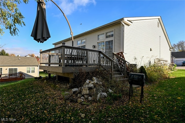 rear view of house featuring a lawn and a wooden deck