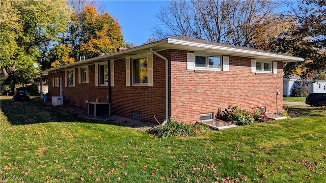 view of side of property with central AC and a yard