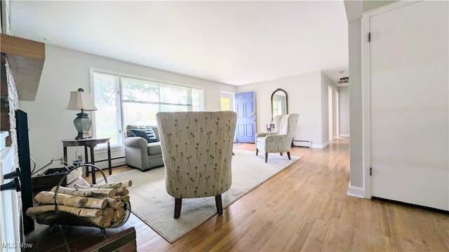 living room with light wood-type flooring and a baseboard radiator