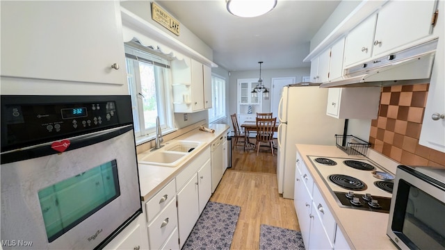 kitchen with stainless steel appliances, white cabinets, sink, and pendant lighting