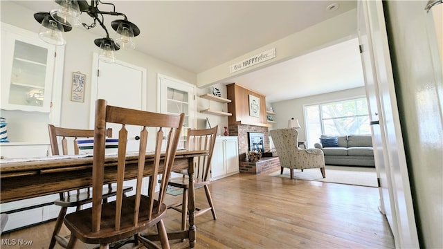 dining space featuring light wood-type flooring and a fireplace