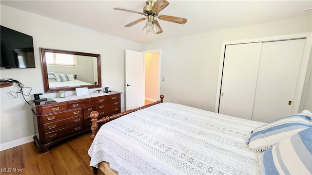 bedroom with dark wood-type flooring, ceiling fan, and a closet