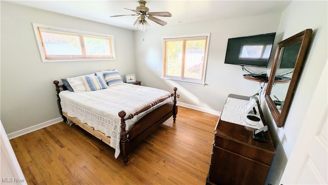 bedroom with hardwood / wood-style floors, multiple windows, and ceiling fan