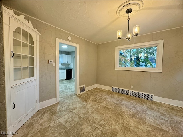 unfurnished dining area featuring an inviting chandelier and crown molding