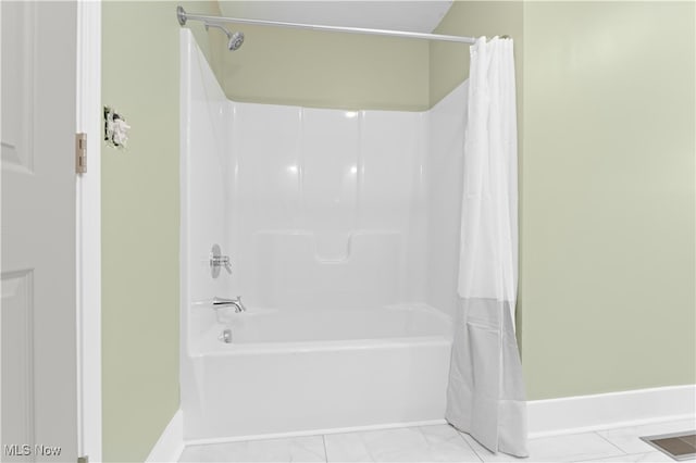 bathroom featuring shower / bath combo with shower curtain and tile patterned flooring