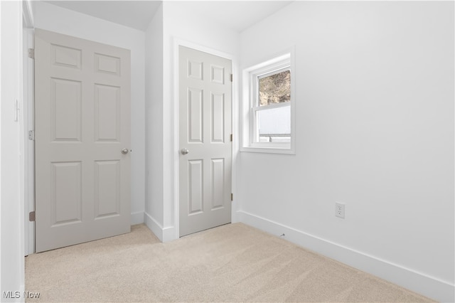 unfurnished bedroom with a closet and light colored carpet