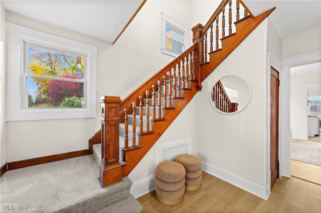 stairs featuring wood-type flooring and a wealth of natural light