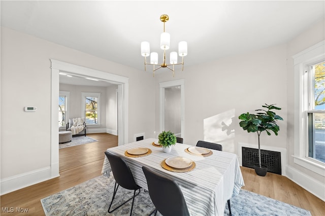 dining area featuring hardwood / wood-style flooring and a chandelier