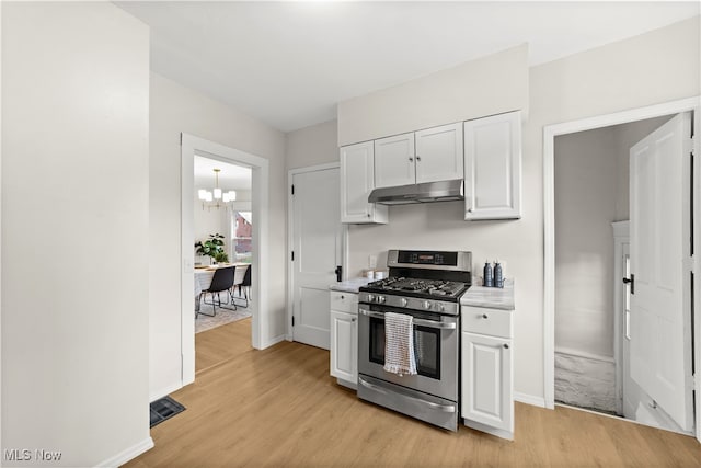 kitchen with a chandelier, white cabinetry, stainless steel gas stove, and light hardwood / wood-style floors