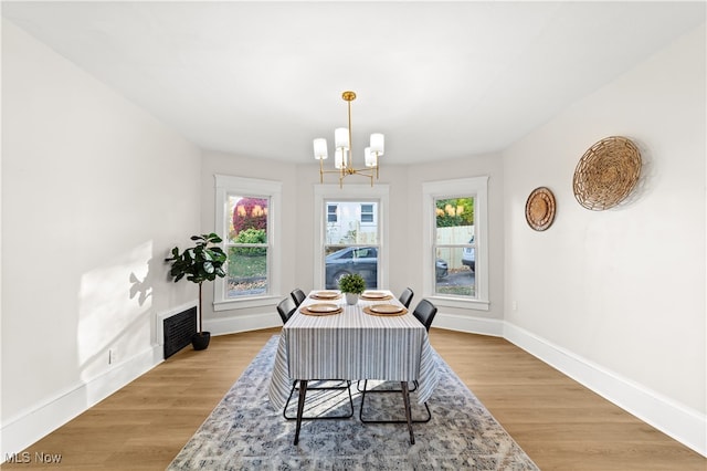 dining area featuring hardwood / wood-style floors, plenty of natural light, and a notable chandelier