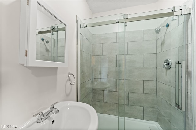 bathroom with an enclosed shower and sink