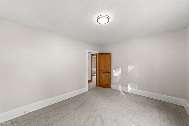 carpeted empty room with a textured ceiling