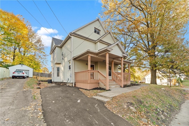 view of front of house featuring covered porch, an outbuilding, and a garage