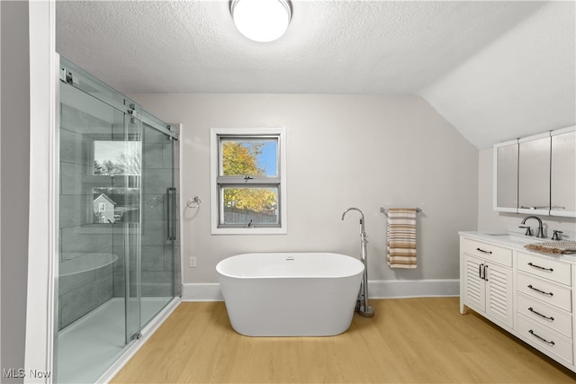 bathroom featuring hardwood / wood-style floors, vanity, separate shower and tub, and lofted ceiling