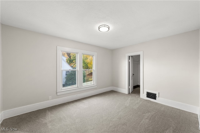 carpeted spare room with a textured ceiling