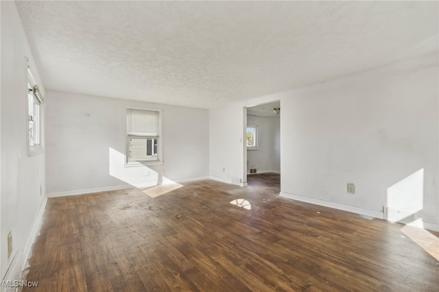 unfurnished living room featuring dark hardwood / wood-style floors, plenty of natural light, and a textured ceiling