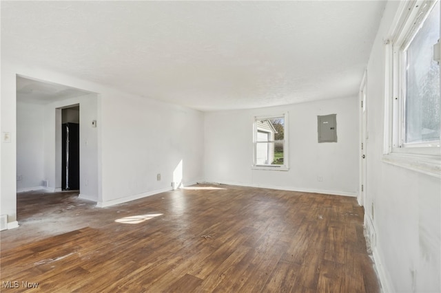 spare room with electric panel and dark hardwood / wood-style flooring