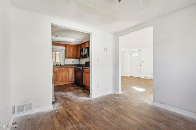 kitchen with sink, black appliances, and dark hardwood / wood-style flooring