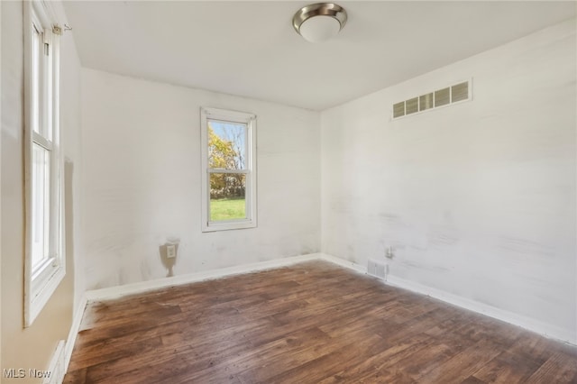 unfurnished room with dark hardwood / wood-style flooring