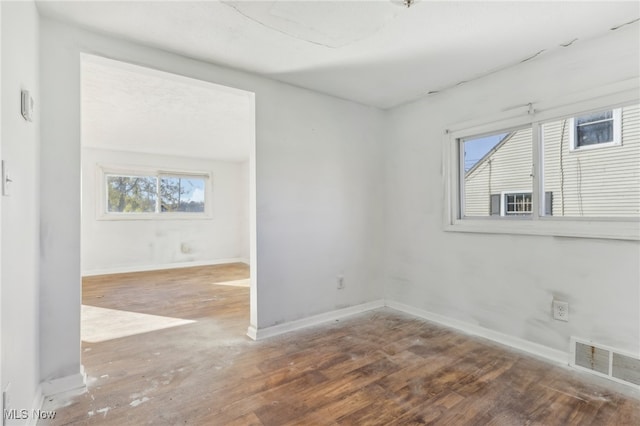 empty room with wood-type flooring and plenty of natural light