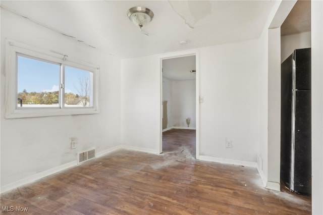 interior space featuring dark hardwood / wood-style floors and stainless steel refrigerator