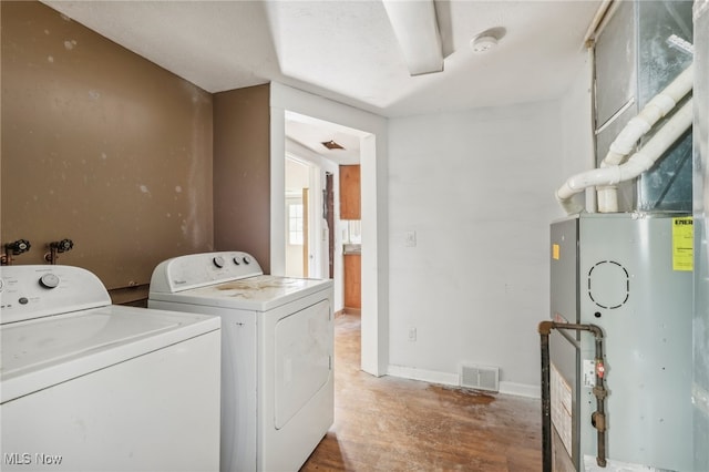 laundry area featuring hardwood / wood-style flooring, washer and clothes dryer, and heating unit