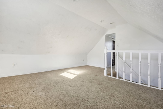 bonus room featuring a textured ceiling, carpet flooring, and vaulted ceiling