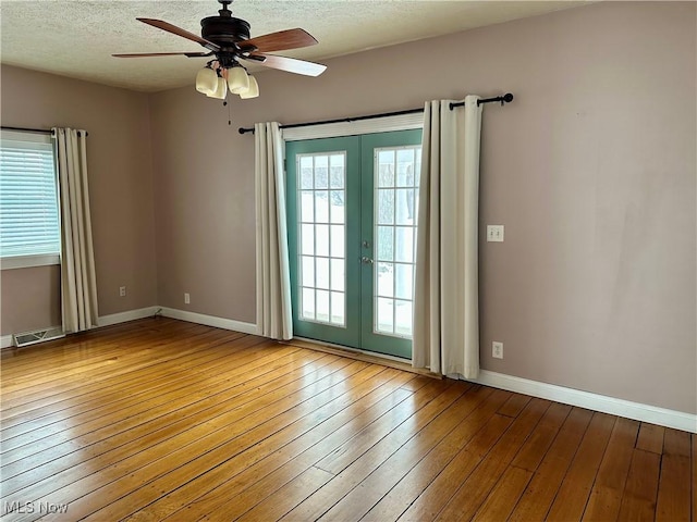 spare room with hardwood / wood-style floors, ceiling fan, a textured ceiling, and french doors