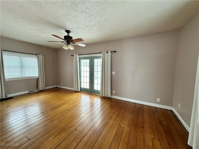 empty room featuring french doors, wood-type flooring, and plenty of natural light